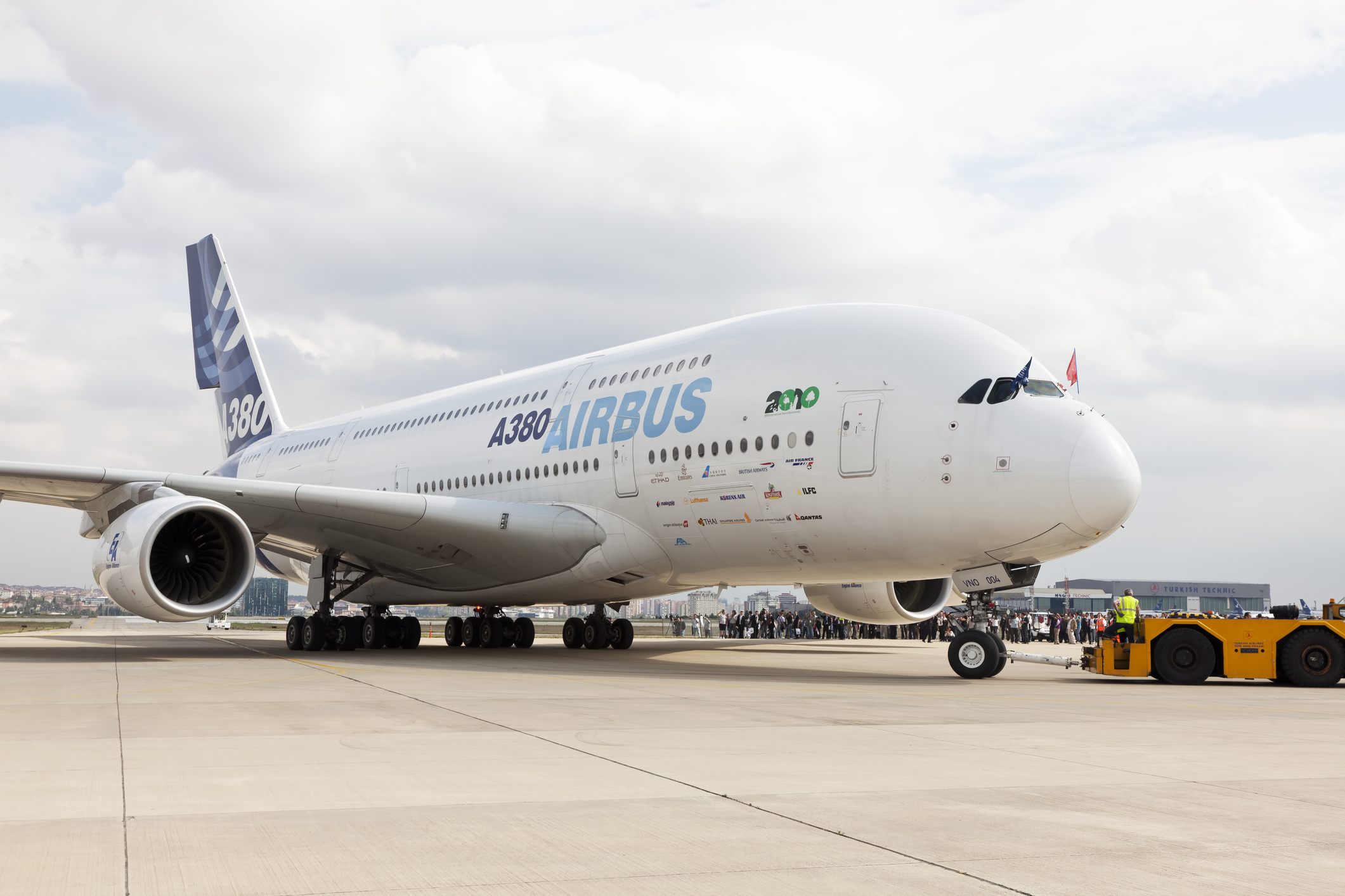 Ein Airbus A380 auf dem Rollfeld mit Flugzeugbeobachtern im Hintergrund.
