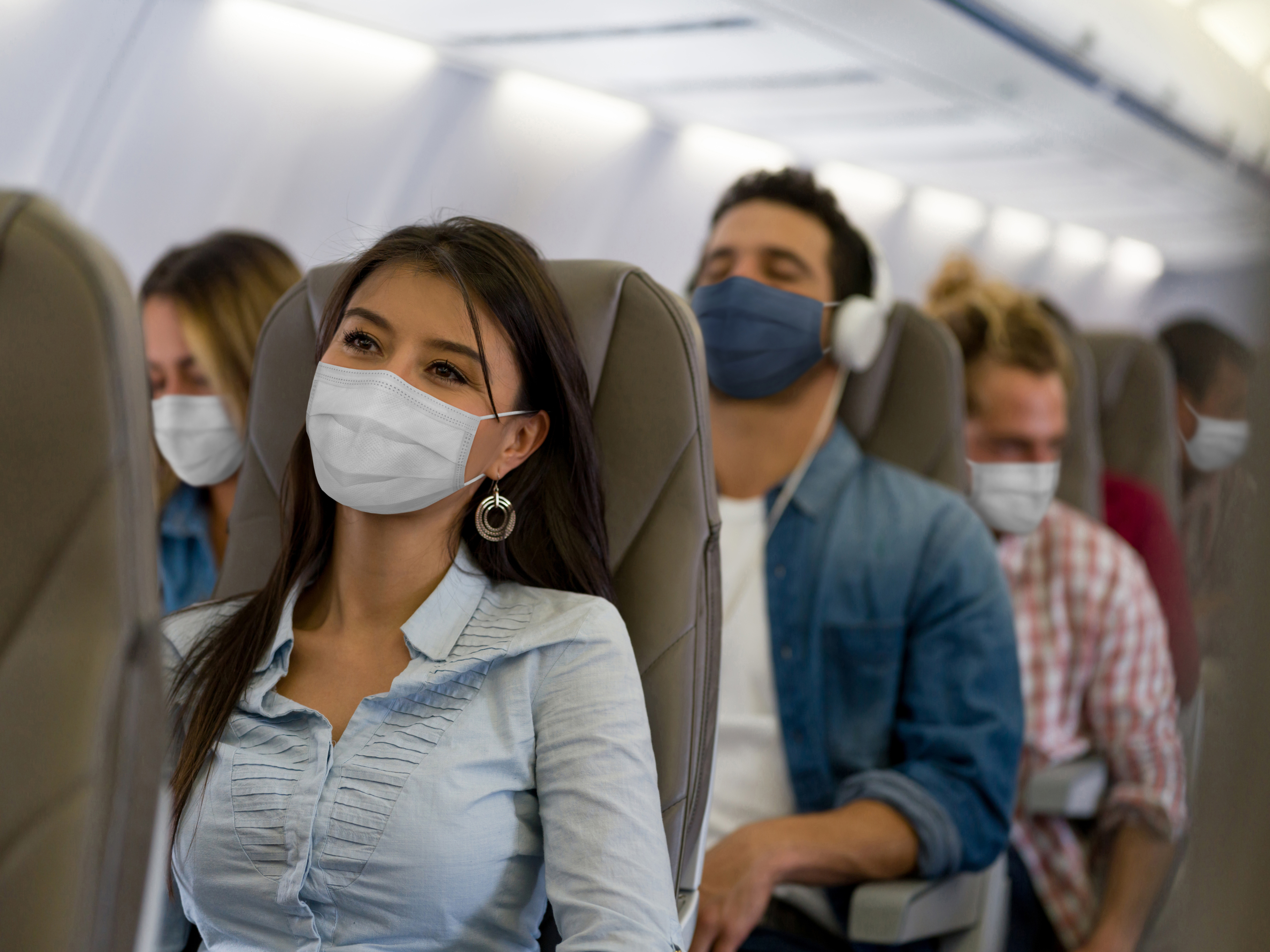 Passagiere mit Masken im Flugzeug