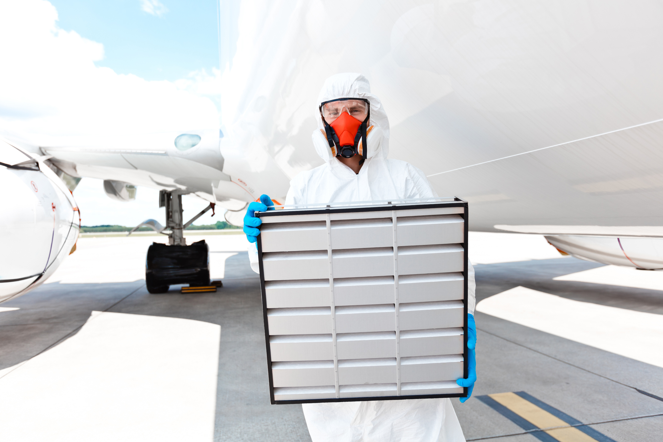 Vliegtuig schoonmaker in beschermend pak op de luchthaven