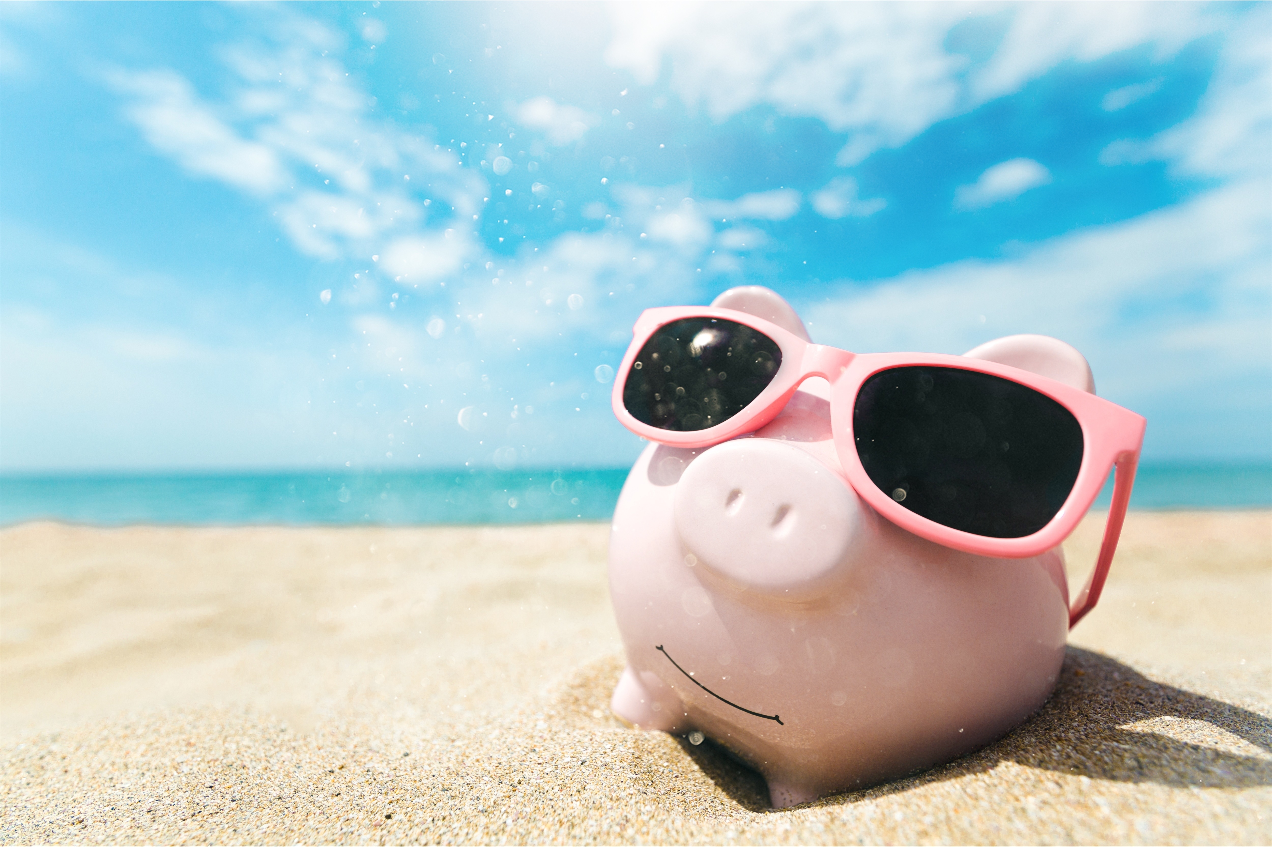 Sparschwein mit Sonnenbrille am Strand