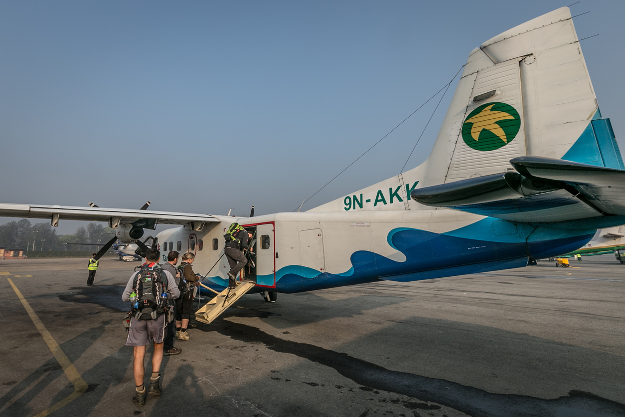 Ein Propellerflugzeug in Nepal, in welches gerade Passagiere einsteigen.