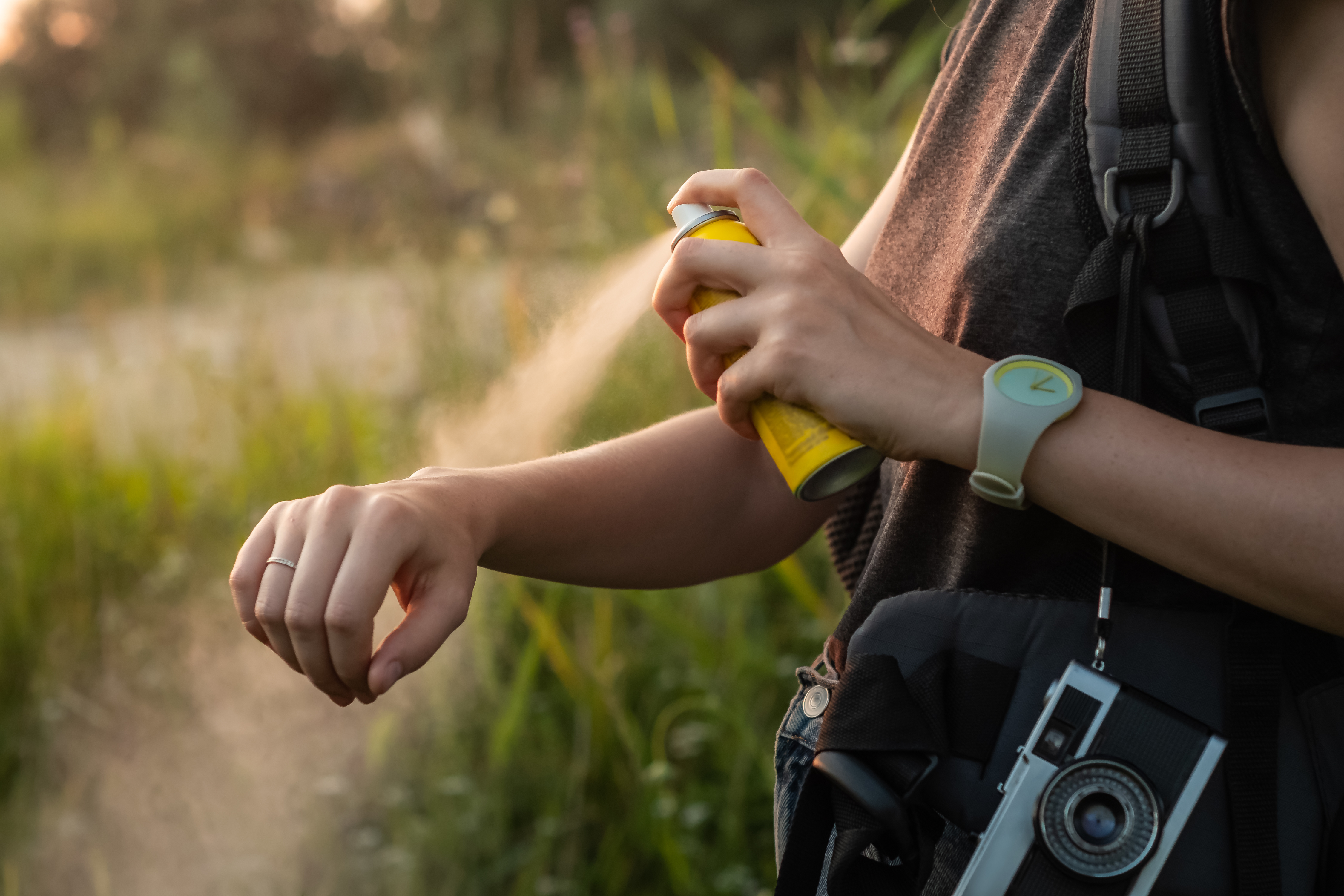 Mückenspray im Freien auf den Arm aufsprühen