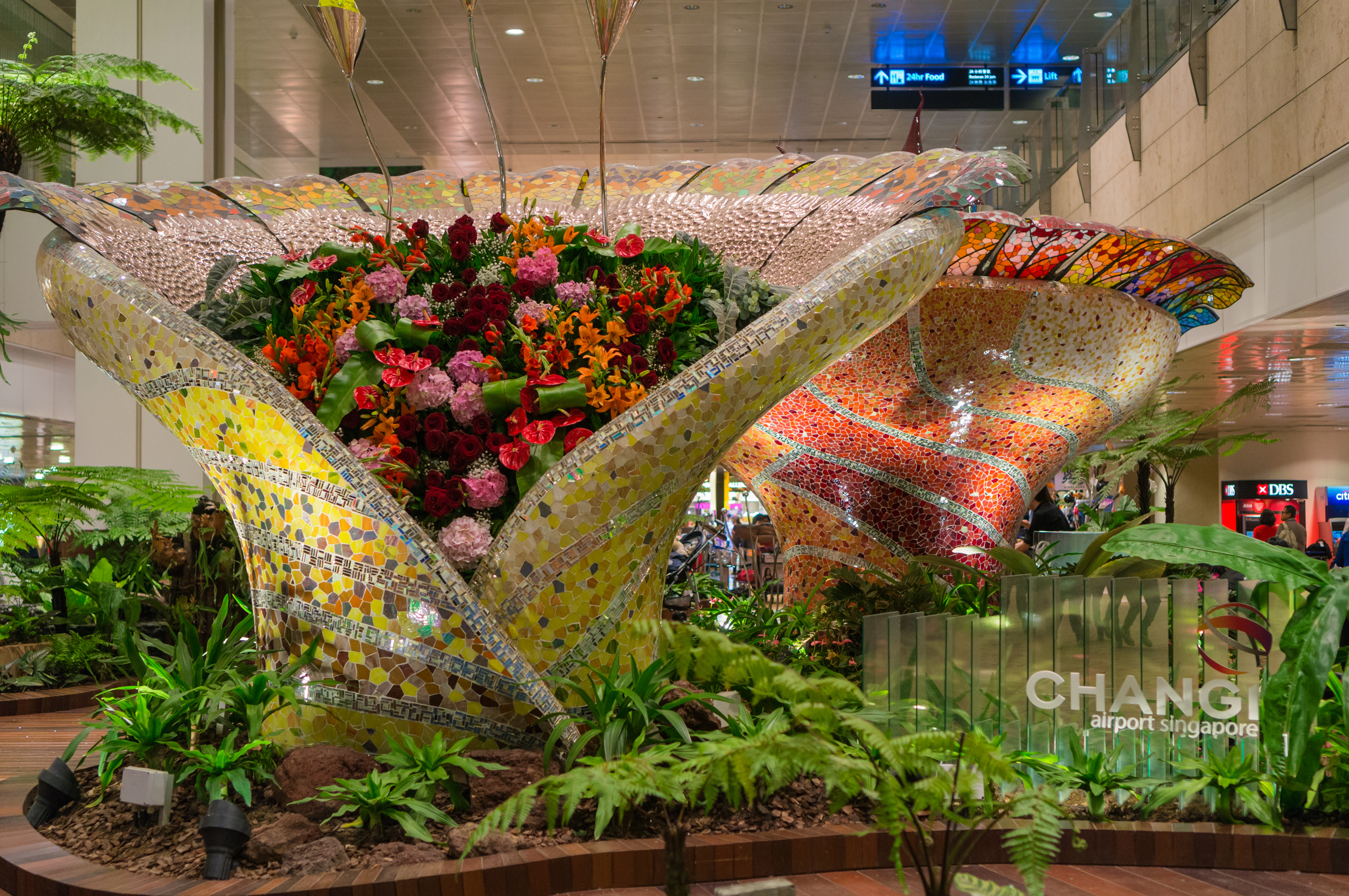 Zwei sehr große, mit kunstvollen Mosaiken verzierte Blumenkästen im inneren des Changi Airports.