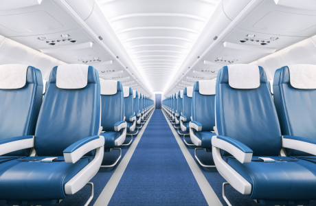Leerer Gang im komplett leeren Flugzeug mit blauem Teppich, weißer Decke und blau-weißen Ledersitzen
