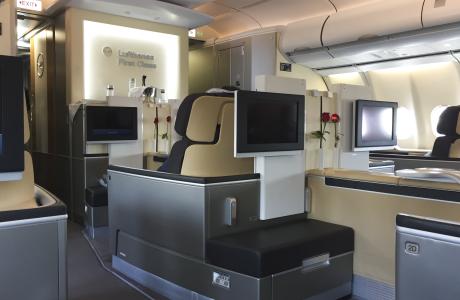 Lufthansa First Class mit einigen Sitzen und Monitoren.