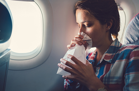 Frau mit Spuckbeutel im Flugzeug