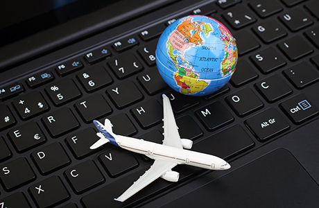 Laptop mit Flugzeug und Globus